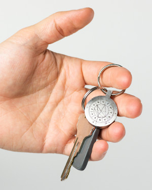 StarCharm personalized natal chart key fob shown in a person's hand