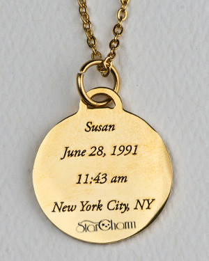 Back side of gold-colored StarCharm personalized pendant engraved with the name, birth date and time, and birthplace of the person whose astrological natal chart appears on the front side